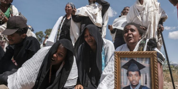 Grief: Mourners at the mass grave of 81 people killed in the city of Wukro | AFP