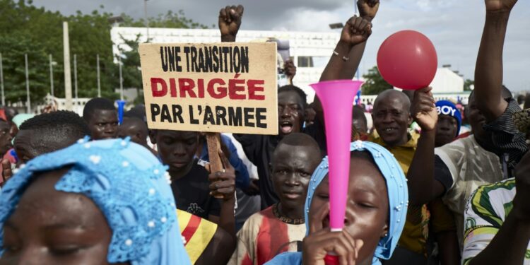 Malians rally in support of the junta several weeks after the 2020 coup. The sign reads: 'A transition led by the army' | AFP