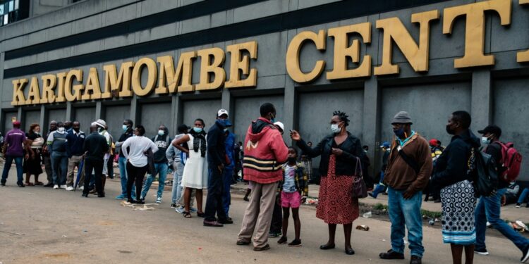 Greenback shortage: People in Harare line up to withdraw US dollars on Christmas Eve. Some were so desperate for hard currency that they even slept in the queue to keep their place | AFP