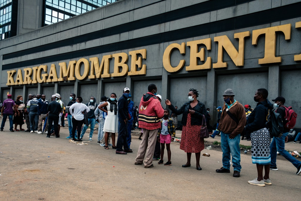 Greenback shortage: People in Harare line up to withdraw US dollars on Christmas Eve. Some were so desperate for hard currency that they even slept in the queue to keep their place | AFP