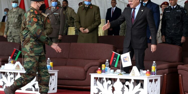Libyan interim Prime Minister Abdulhamid Dbeibah (R) greets Lieutenant General Mohammad Ali al-Haddad (L), chief of the general staff of the Libyan army, during a military graduation ceremony in the capital Tripoli on January 23, 2022 | AFP