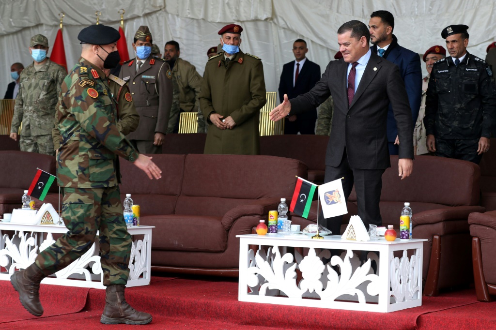 Libyan interim Prime Minister Abdulhamid Dbeibah (R) greets Lieutenant General Mohammad Ali al-Haddad (L), chief of the general staff of the Libyan army, during a military graduation ceremony in the capital Tripoli on January 23, 2022 | AFP
