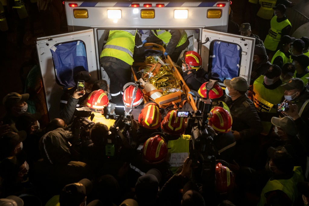 Moroccan emergency services teams carry the body of five-year-old Rayan into an ambulance after pulling him from a well shaft | AFP