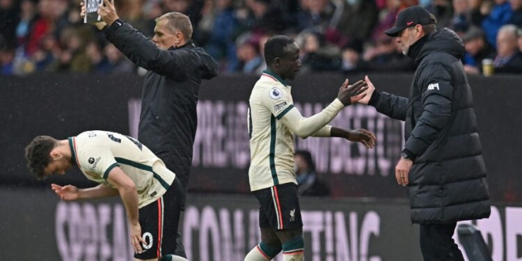 Liverpool forward Sadio Mane (C) taps hands with manager Jurgen Klopp (R) after being substituted during a Premier League match at Burnley on February 13 | AFP
