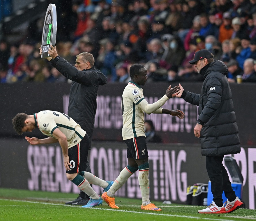 Liverpool forward Sadio Mane (C) taps hands with manager Jurgen Klopp (R) after being substituted during a Premier League match at Burnley on February 13 | AFP