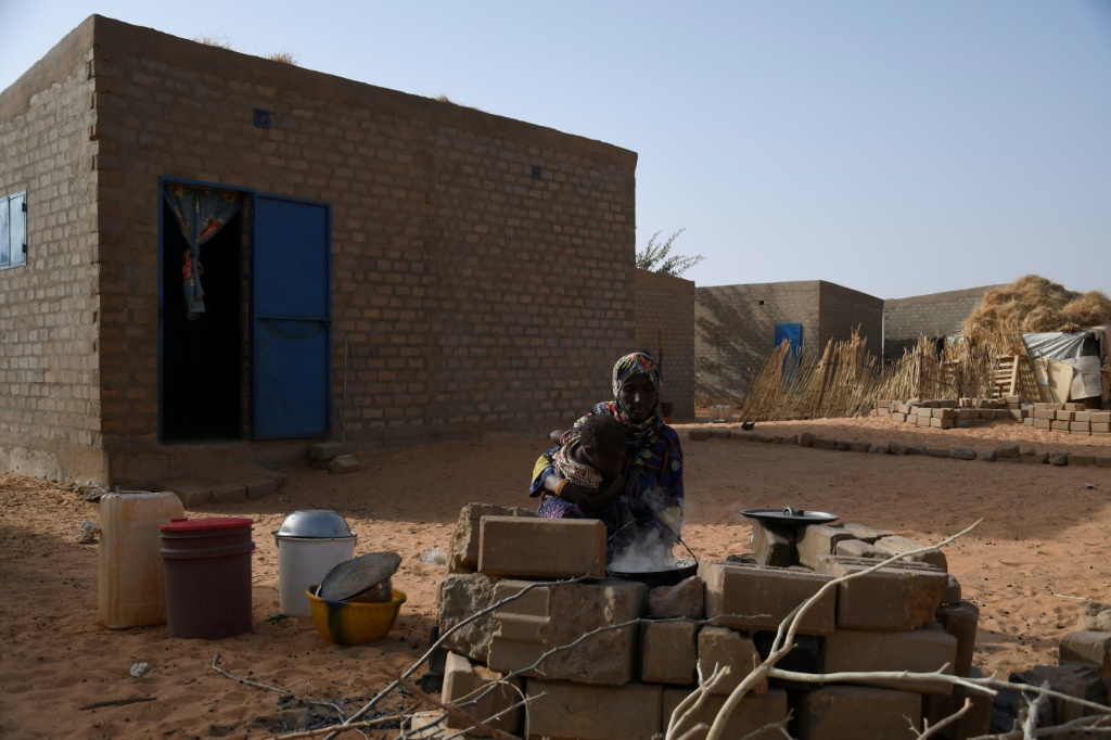 A Malian refugee cooks outside her home in Ouallam | AFP