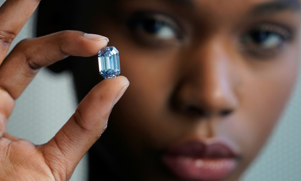 Model Stephany Martins holds up the "The De Beers Cullinan Blue" blue diamond during a press preview at Sotheby's in New York, on February 15, 2022 | AFP