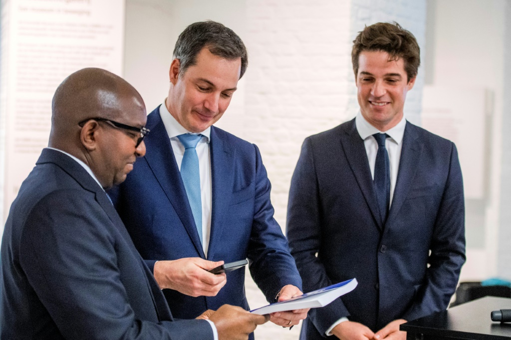 DR Congo's prime minister, Jean-Michel Sama Lukonde, receives the inventory of looted artefacts from Belgian Prime Minister Alexander De Croo, centre. At right is the Belgian state secretary for scientific policy, Thomas Dermine | AFP
