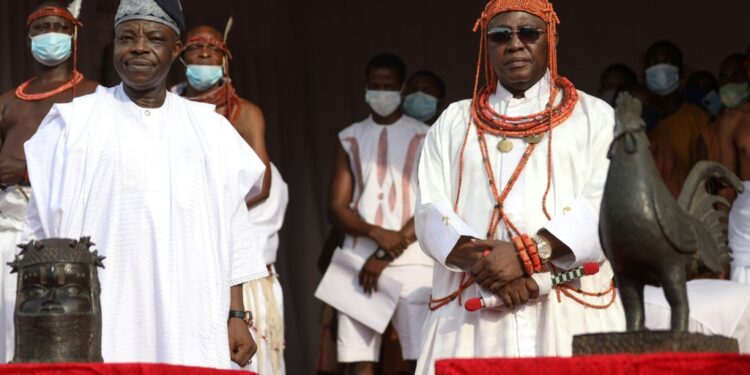 The King, known as Oba of Benin (right) received the artefacts | AFP