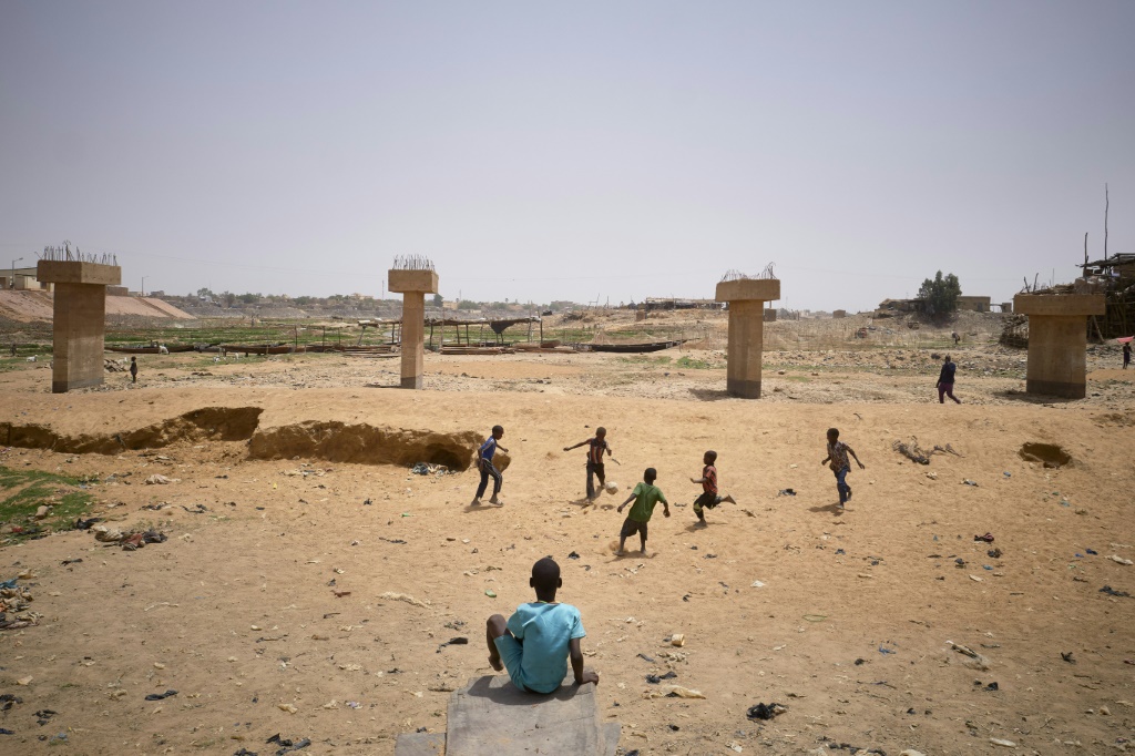 Children playing football in a dry arm of the inner delta of the Niger River, March 19, 2021 | AFP