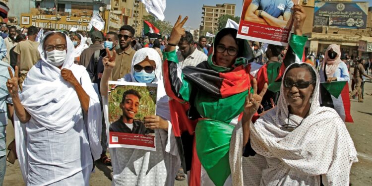 Demonstrators in Khartoum North hold pictures of protesters killed in earlier demonstrations, during a march calling for civilian rule | AFP