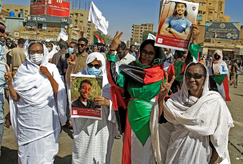 Demonstrators in Khartoum North hold pictures of protesters killed in earlier demonstrations, during a march calling for civilian rule | AFP