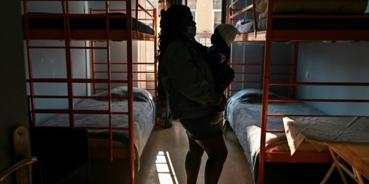 Congolese refugee and domestic violence victim Ruth holds the youngest of her three sons in a shelter for abused women in Athens | AFP