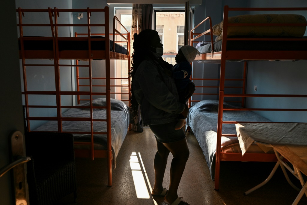 Congolese refugee and domestic violence victim Ruth holds the youngest of her three sons in a shelter for abused women in Athens | AFP