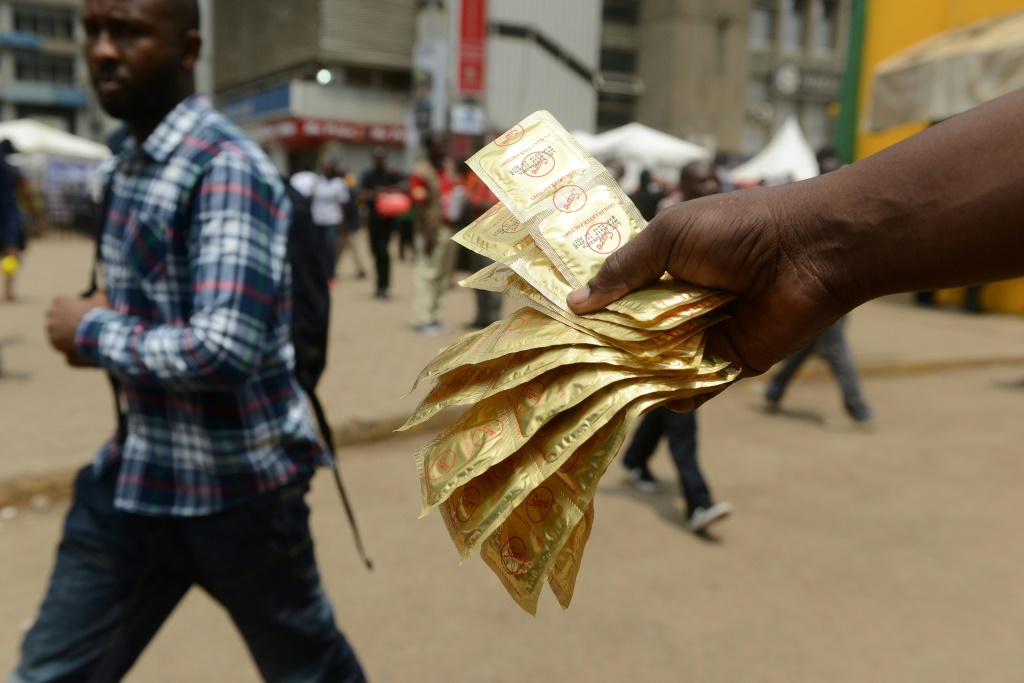 A healthcare worker distributes condoms in Kenya's capital Nairobi. Around 1.1 million condoms donated to the country have disappeared from a government warehouse | AFP