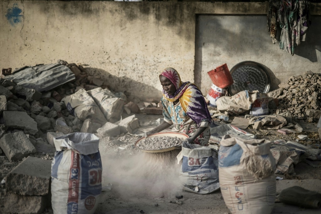A woman sifts gravel from sand with an improvised sieve in N'Djamena, the capital of Chad, in April 2021: the IMF said Chad needs debt restructuring to help its economy | AFP