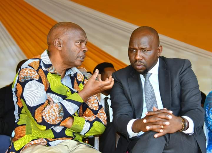 Makueni Governor Kivutha Kibwana  has a word with Senator Kipchumba Murkomen during the burial of Janet Nduya in Machakos.