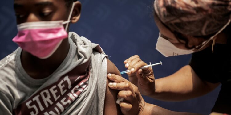 A boy receives a dose of the Pfizer/BioNTech vaccine against COVID-19 at Discovery vaccination site in Sandton, Johannesburg | AFP