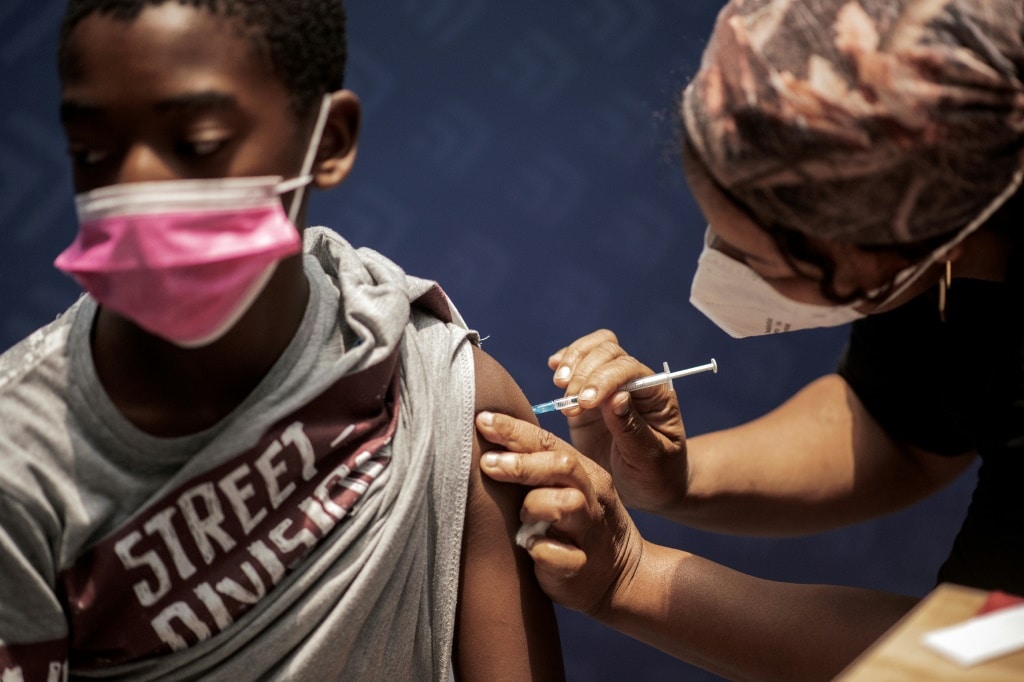 A boy receives a dose of the Pfizer/BioNTech vaccine against COVID-19 at Discovery vaccination site in Sandton, Johannesburg | AFP