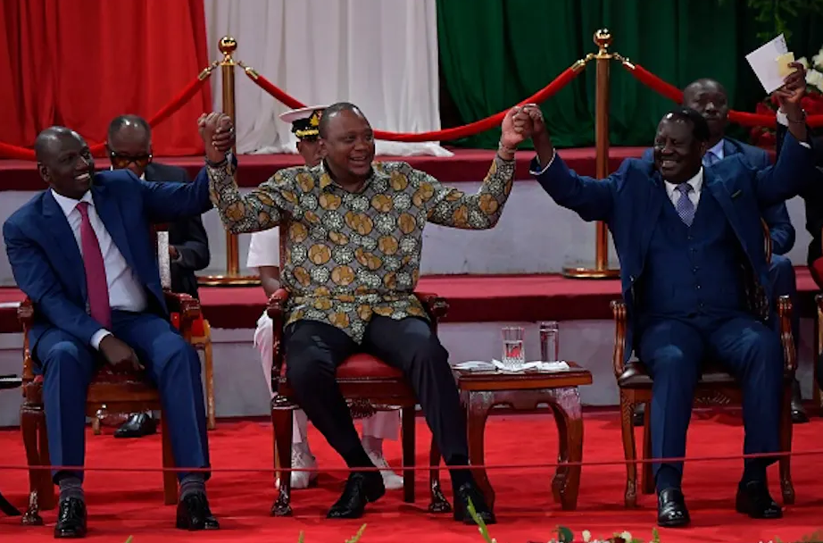 Uhuru Kenyatta (centre) holds hands with opinion polls’ favourites, Deputy President William Ruto (left) and former Prime Minister Raila Odinga | Tony Karumba/AFP via Getty Images