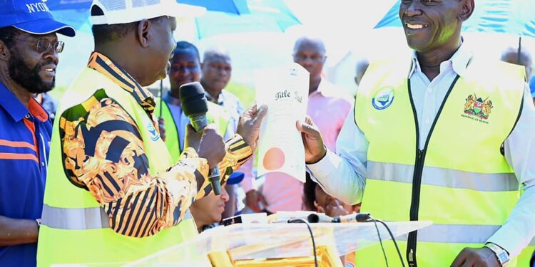 Raila Odinga hands over a title deed for a land he donated for a water project.Photo/Courtesy