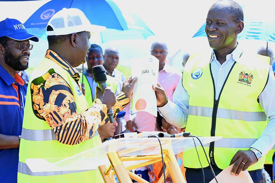 Raila Odinga hands over a title deed for a land he donated for a water project.Photo/Courtesy