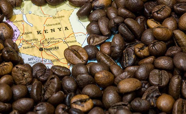 Geographical map of Kenya covered by a background of roasted coffee beans. This nation is one of the main producers and exporters of coffee. Horizontal closeup image.