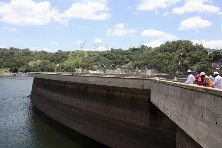 Officials inspect water levels on the Kariba Dam in Zimbabwe. 
Photograph: Philimon Bulawayo/Reuters]