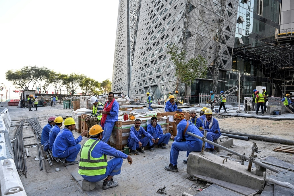 Migrant builders take a break while working at a construction site by the Corniche in Doha during the World Cup | AFP