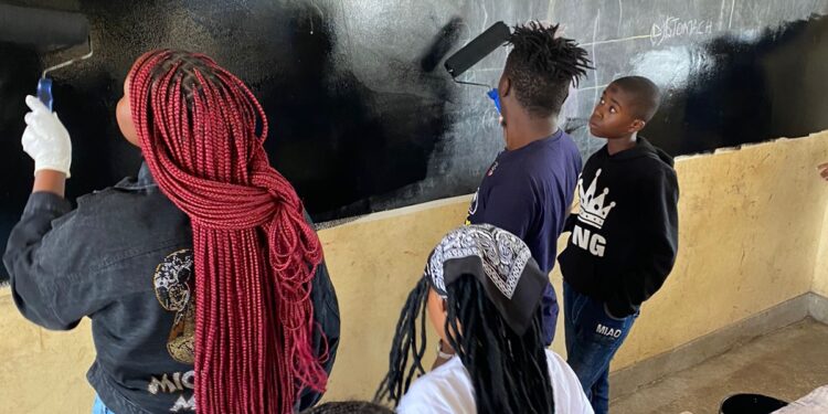 The Club President Fred Kyule paints a blackboard at Kwa Mang'eli Primary alongside members of the club and pupils from the school: Photo Courtesy of the Rotaract Club of Athi-River