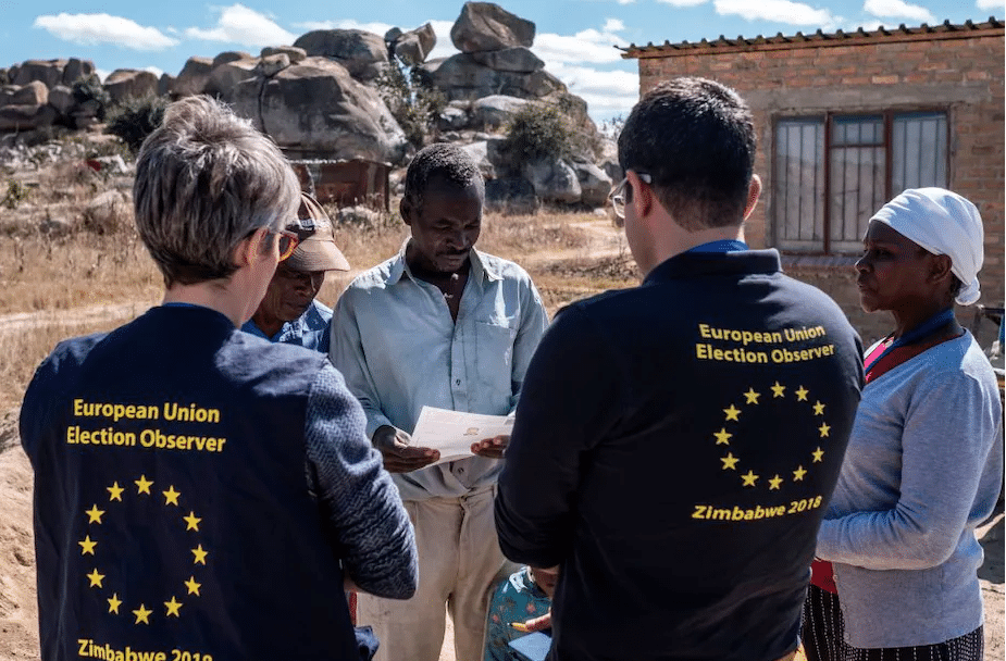 Members of a European Union election observation team speak to voters in Zimbabwe |  
 Marco Longari/AFP via Getty Images