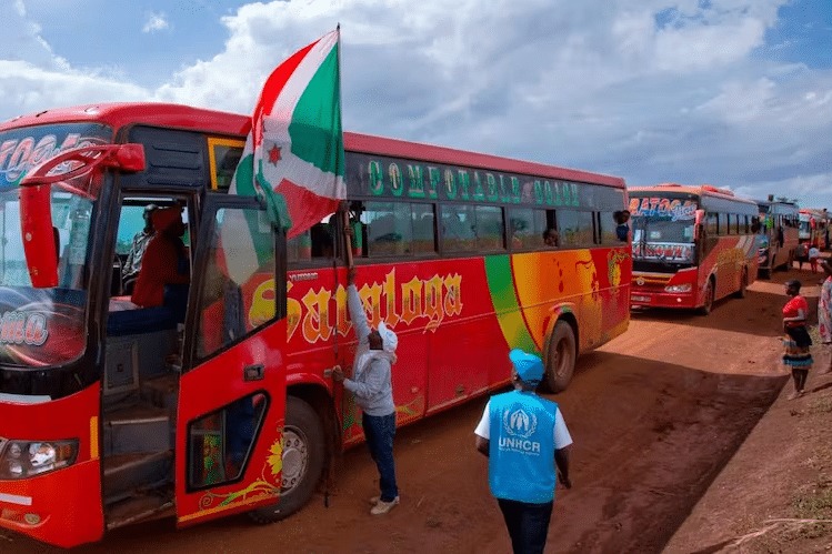 The Burundian flag flies at the head of a convoy of buses moving refugees back home from Tanzania in 2019 | Tchandrou Nitanga/AFP via Getty Images