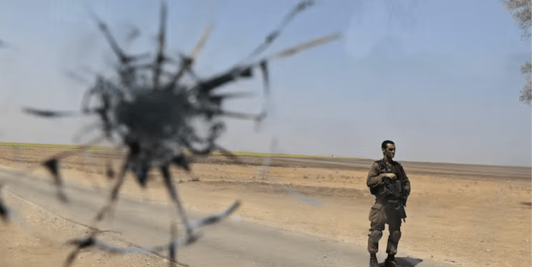 An Israeli soldier, seen through a shattered window of an Israeli army vehicle, near the Gaza border in southern Israel, August, 2010 | Tsafrir Abayov/AP