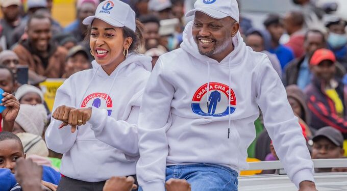 Faith Mwaura (left) and Trade CS Moses Kuria (right) atop a vehicle during campaigns in 2022