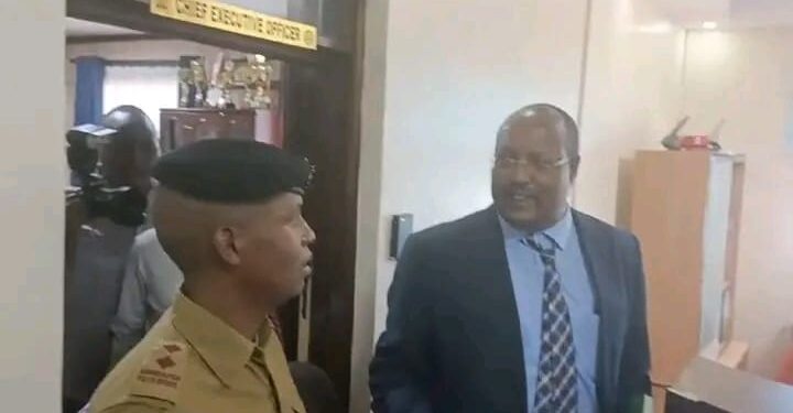 The besieged Rift Valley Water Works CEO Samuel Oruma engages a police delpoyed at the company's headquarters in Nakuru.