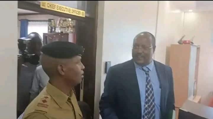 The besieged Rift Valley Water Works CEO Samuel Oruma engages a police delpoyed at the company's headquarters in Nakuru.