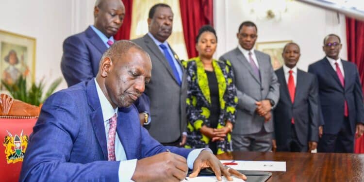 President William Ruto signs the Finance Bill 2023 into law on June 26, 2023. Looking on are Deputy President Rigathi Gachagua, Prime Cabinet Secretary Musalia Mudavadi and other leaders.