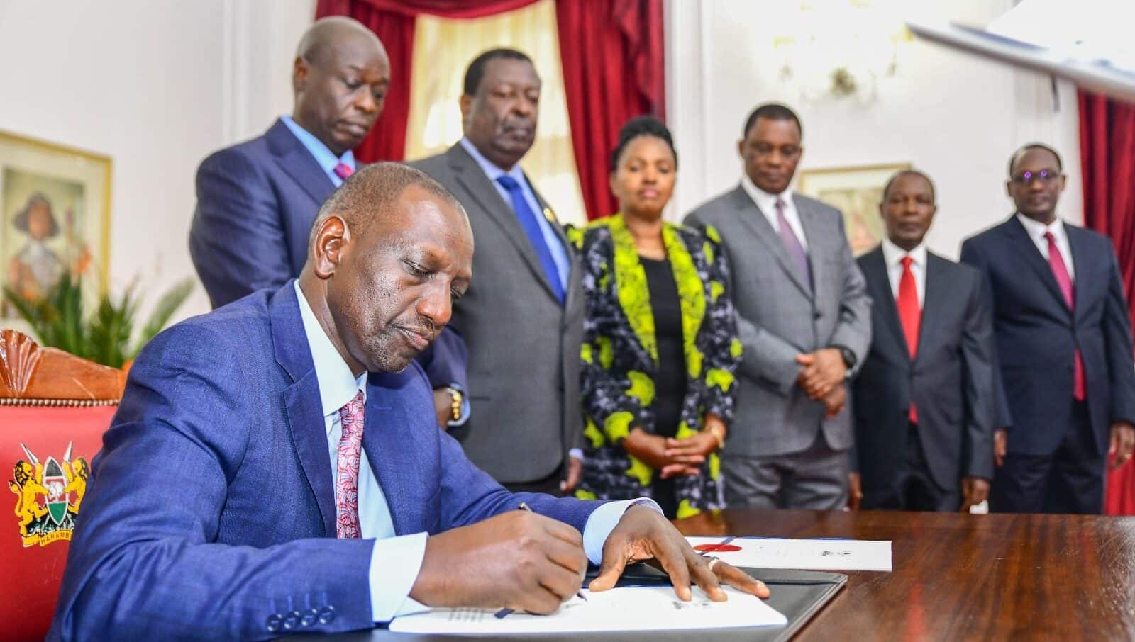 President William Ruto signs the Finance Bill 2023 into law on June 26, 2023. Looking on are Deputy President Rigathi Gachagua, Prime Cabinet Secretary Musalia Mudavadi and other leaders.