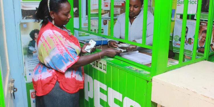 M-PESA agent attending to a customer. SAFARICOM