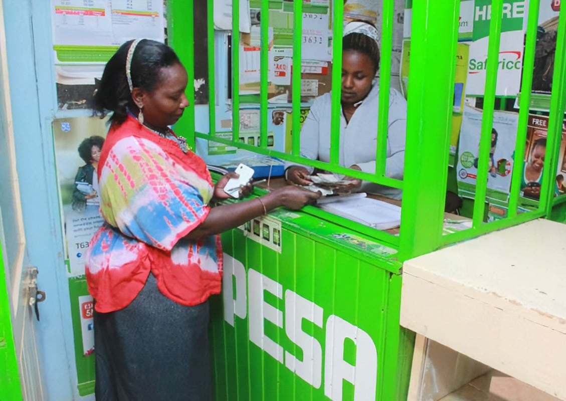 M-PESA agent attending to a customer. SAFARICOM