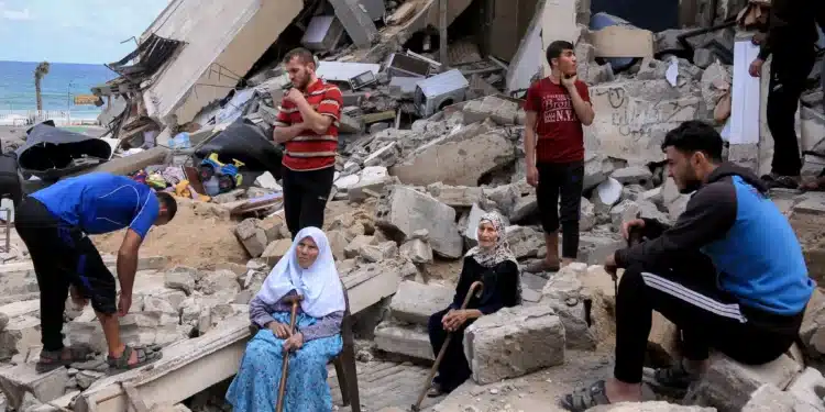 People sitting in the rubble of a bombed house in Gaza after a past attack. PHOTO/Samar Abu Elouf.
