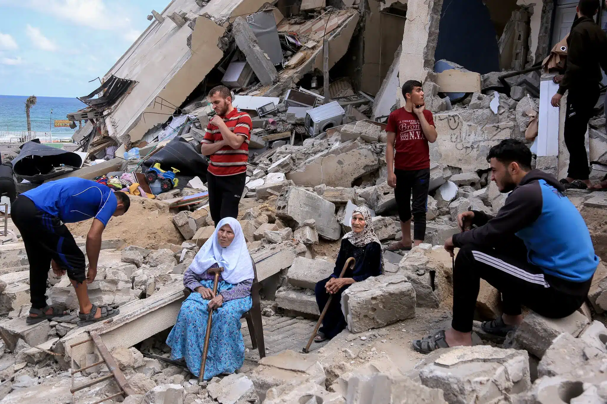 People sitting in the rubble of a bombed house in Gaza after a past attack. PHOTO/Samar Abu Elouf.