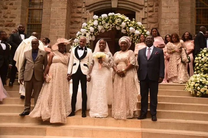 Prime Cabinet Secretary Musalia Mudavadi (right) and his spouse Tessie Mudavadi (next to him) pose for a photo during their daughter's wedding on October 28, 2023 in Nairobi.
