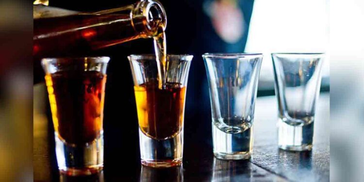 Alcohol being poured into glasses. Alcohol being poured into glasses.