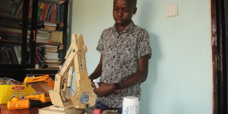 Ethan Simiyu holding the Hydraulic Arm.