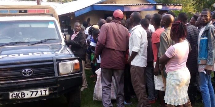 A Photo Of A Police Van And Local Residents At A Past Crime Scene. Kisii