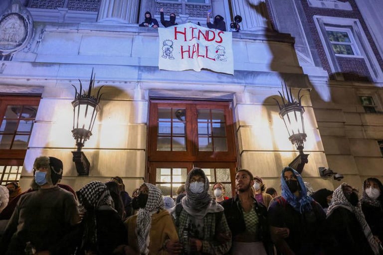 Protesters link arms outside Hamilton Hall barricading students inside the building at Columbia University. PHOTO/ Reuters