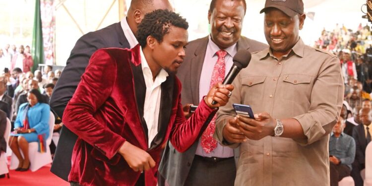 President William Ruto registering for the Hustler Fund on November 30, 2022, as Prime Cabinet Secretary Musalia Mudavadi and Vincent Mutua (Chipukeezy) look on. PCS.