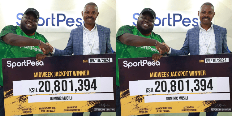 Dominic Musili receives a check after winning Sportpesa's Ksh20.8 million mid-week jackpot.