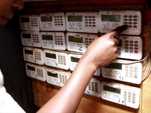 A customer in Loresho, Nairobi, keys in tokens in her meter box. Photo/ Star
